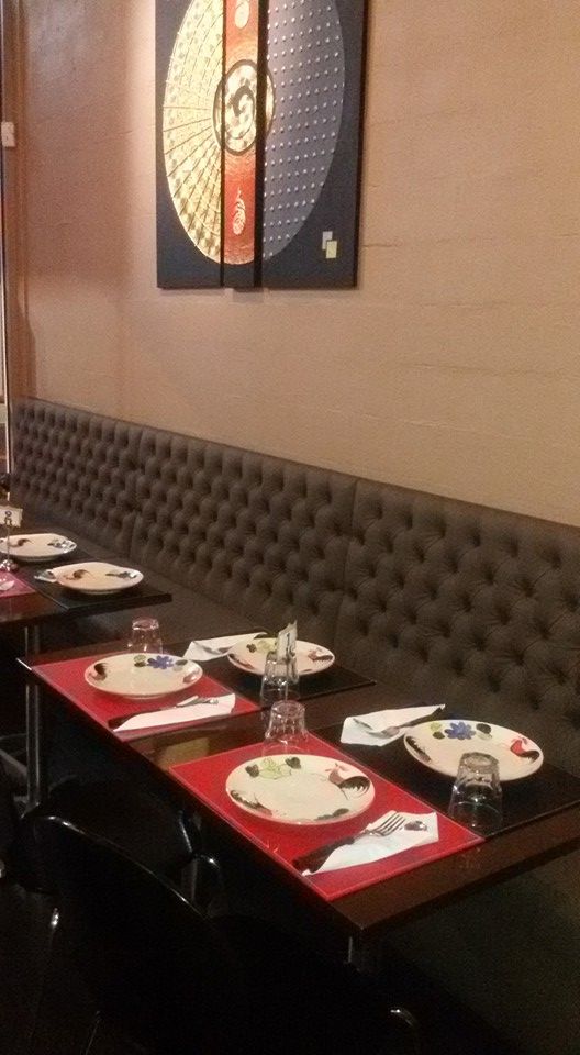 Cozy Mornington Thai interior with dark banquette seating, red placemats and Thai wall art