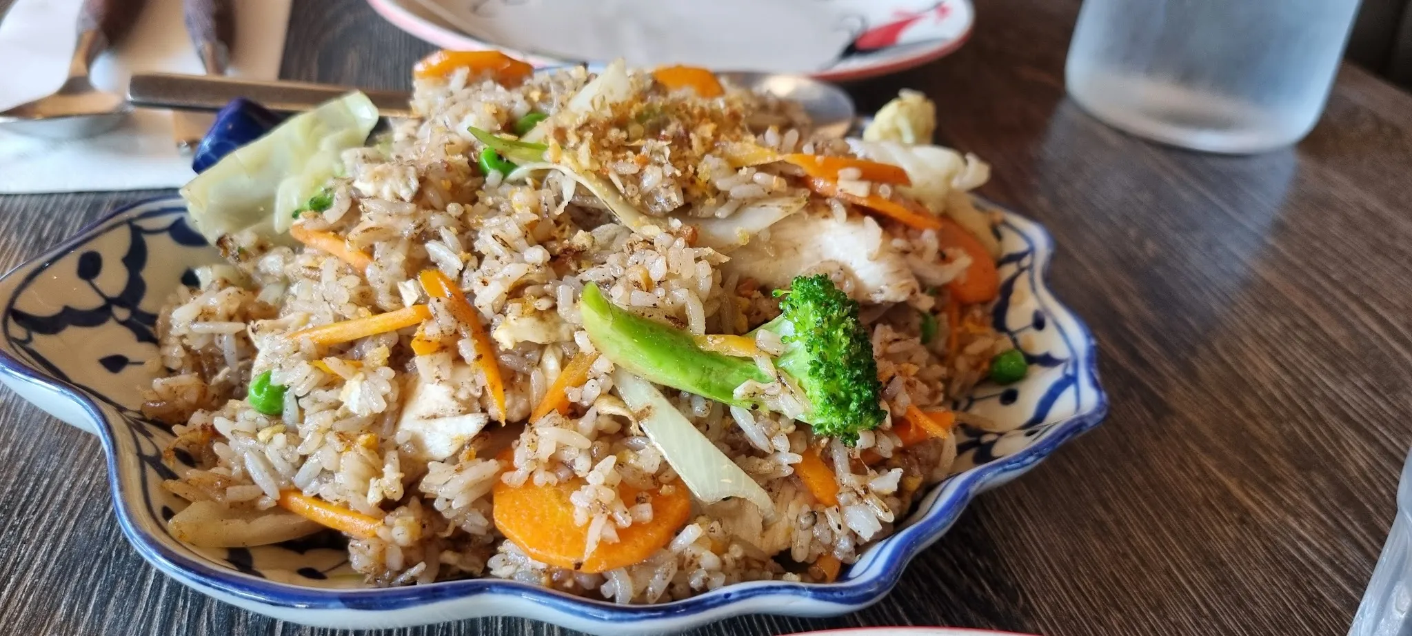 Thai fried rice with vegetables in a decorative blue-and-white Thai ceramic plate