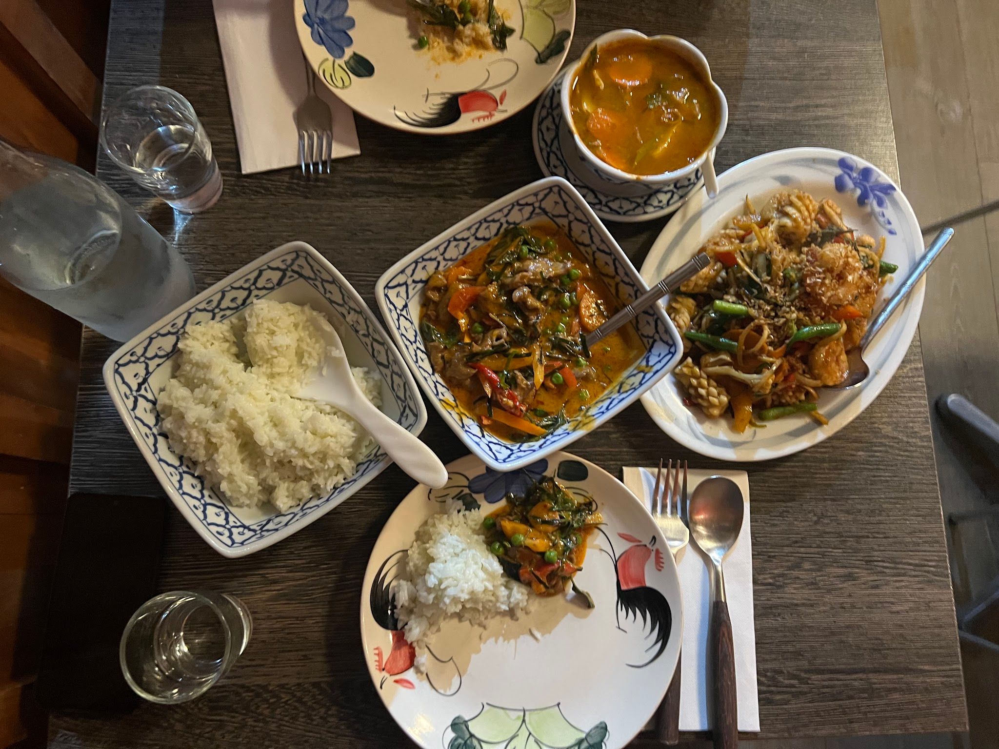 Overhead table spread of multiple Thai dishes in blue-and-white ceramic bowls at Mornington Thai